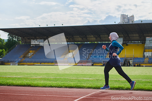 Image of A muslim woman in a burqa sports muslim clothes running on a marathon course and preparing for upcoming competitions