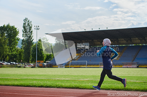 Image of A muslim woman in a burqa sports muslim clothes running on a marathon course and preparing for upcoming competitions