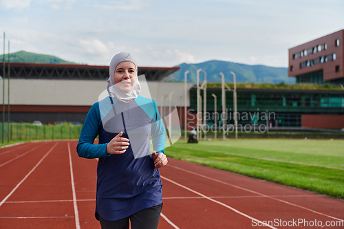 Image of A muslim woman in a burqa sports muslim clothes running on a marathon course and preparing for upcoming competitions