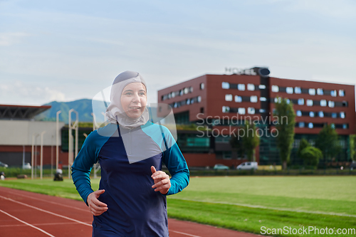 Image of A muslim woman in a burqa sports muslim clothes running on a marathon course and preparing for upcoming competitions