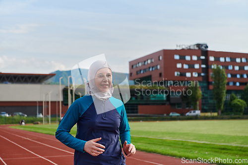 Image of A muslim woman in a burqa sports muslim clothes running on a marathon course and preparing for upcoming competitions