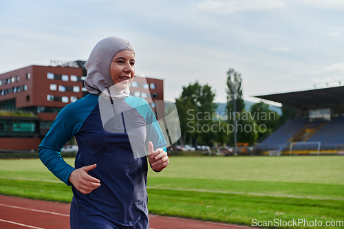 Image of A muslim woman in a burqa sports muslim clothes running on a marathon course and preparing for upcoming competitions