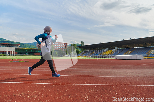 Image of A muslim woman in a burqa sports muslim clothes running on a marathon course and preparing for upcoming competitions