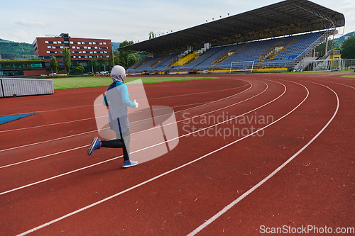 Image of A muslim woman in a burqa sports muslim clothes running on a marathon course and preparing for upcoming competitions