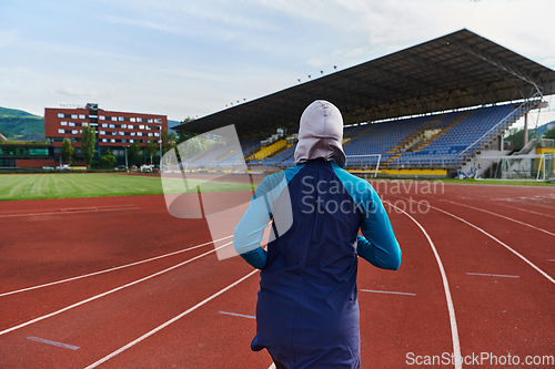 Image of A muslim woman in a burqa sports muslim clothes running on a marathon course and preparing for upcoming competitions