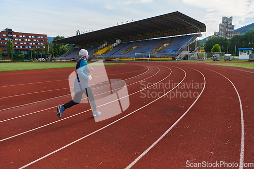 Image of A muslim woman in a burqa sports muslim clothes running on a marathon course and preparing for upcoming competitions