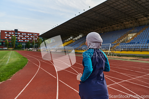 Image of A muslim woman in a burqa sports muslim clothes running on a marathon course and preparing for upcoming competitions