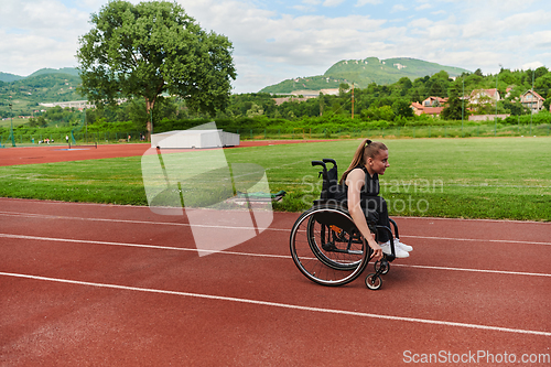 Image of A woman with disablity driving a wheelchair on a track while preparing for the Paralympic Games