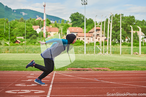 Image of A muslim woman in a burqa sports muslim clothes running on a marathon course and preparing for upcoming competitions