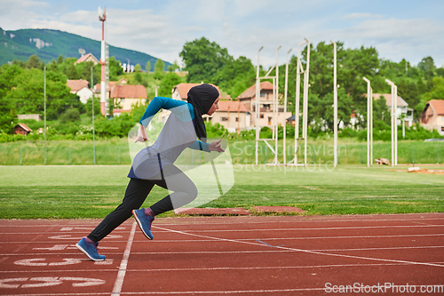 Image of A muslim woman in a burqa sports muslim clothes running on a marathon course and preparing for upcoming competitions