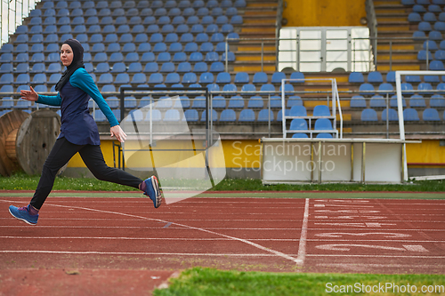 Image of A muslim woman in a burqa sports muslim clothes running on a marathon course and preparing for upcoming competitions