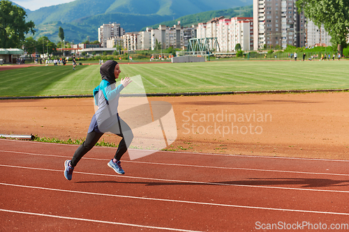 Image of A muslim woman in a burqa sports muslim clothes running on a marathon course and preparing for upcoming competitions