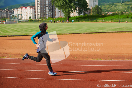 Image of A muslim woman in a burqa sports muslim clothes running on a marathon course and preparing for upcoming competitions