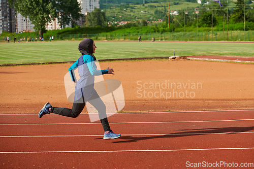 Image of A muslim woman in a burqa sports muslim clothes running on a marathon course and preparing for upcoming competitions