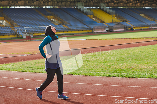 Image of A Muslim woman with a burqa, an Islamic sportswoman resting after a vigorous training session on the marathon course. A hijab woman is preparing for a marathon competition