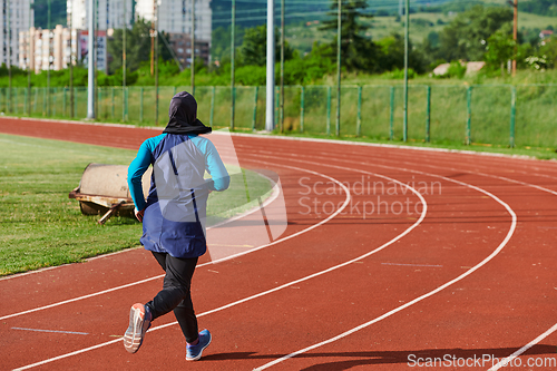 Image of A muslim woman in a burqa sports muslim clothes running on a marathon course and preparing for upcoming competitions