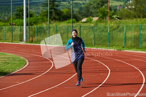 Image of A muslim woman in a burqa sports muslim clothes running on a marathon course and preparing for upcoming competitions