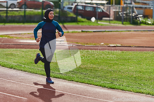 Image of A muslim woman in a burqa sports muslim clothes running on a marathon course and preparing for upcoming competitions