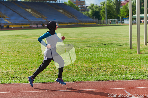 Image of A muslim woman in a burqa sports muslim clothes running on a marathon course and preparing for upcoming competitions