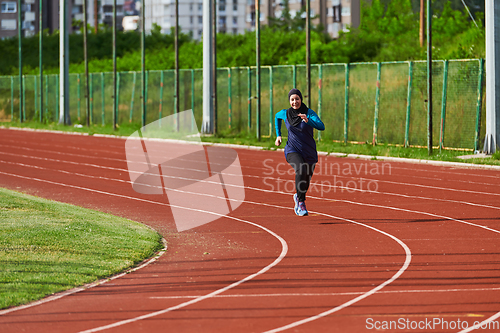 Image of A muslim woman in a burqa sports muslim clothes running on a marathon course and preparing for upcoming competitions