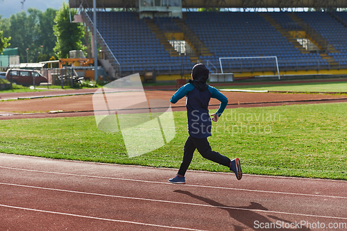 Image of A muslim woman in a burqa sports muslim clothes running on a marathon course and preparing for upcoming competitions