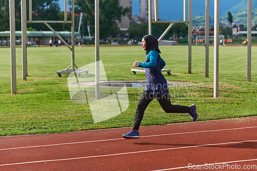 Image of A muslim woman in a burqa sports muslim clothes running on a marathon course and preparing for upcoming competitions