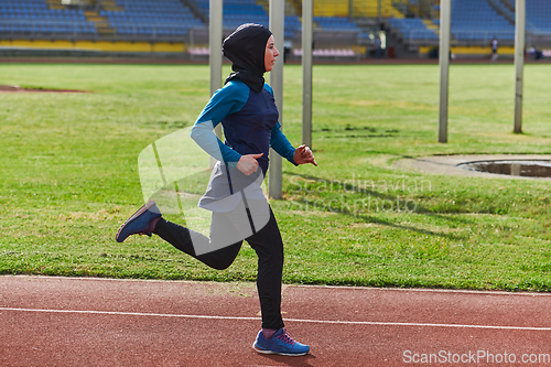 Image of A muslim woman in a burqa sports muslim clothes running on a marathon course and preparing for upcoming competitions