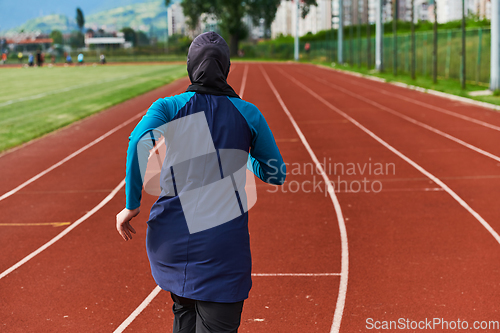 Image of A muslim woman in a burqa sports muslim clothes running on a marathon course and preparing for upcoming competitions