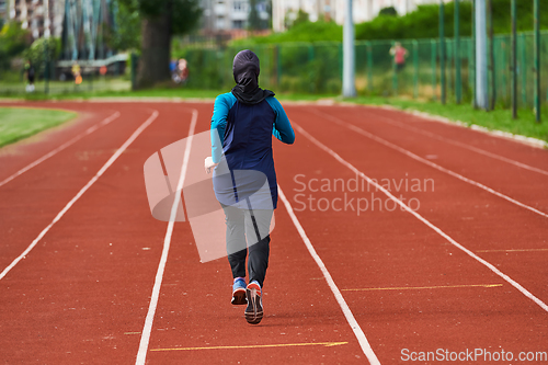 Image of A muslim woman in a burqa sports muslim clothes running on a marathon course and preparing for upcoming competitions