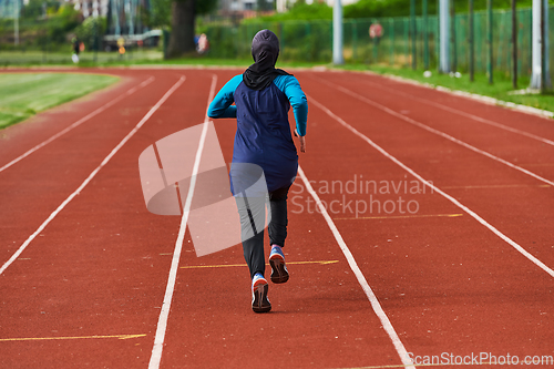 Image of A muslim woman in a burqa sports muslim clothes running on a marathon course and preparing for upcoming competitions