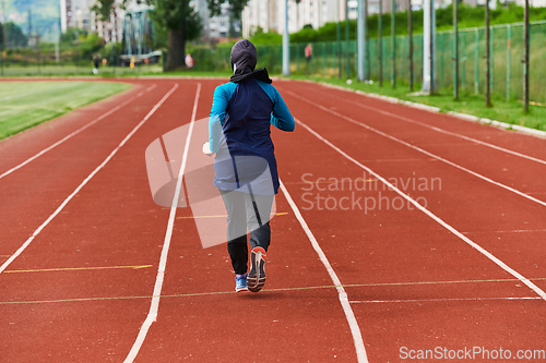 Image of A muslim woman in a burqa sports muslim clothes running on a marathon course and preparing for upcoming competitions