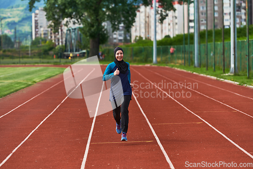 Image of A muslim woman in a burqa sports muslim clothes running on a marathon course and preparing for upcoming competitions