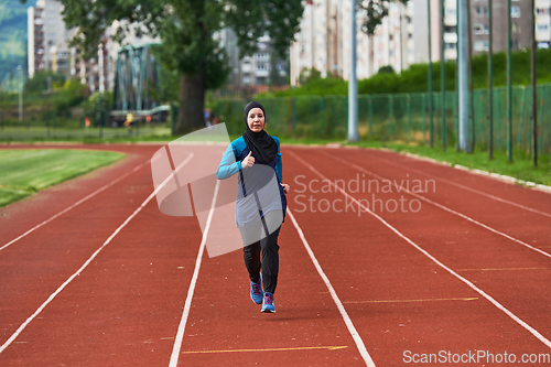 Image of A muslim woman in a burqa sports muslim clothes running on a marathon course and preparing for upcoming competitions