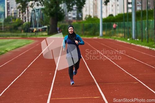 Image of A muslim woman in a burqa sports muslim clothes running on a marathon course and preparing for upcoming competitions