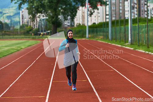 Image of A muslim woman in a burqa sports muslim clothes running on a marathon course and preparing for upcoming competitions