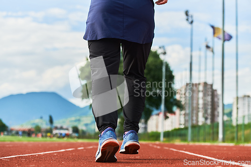 Image of A muslim woman in a burqa sports muslim clothes running on a marathon course and preparing for upcoming competitions