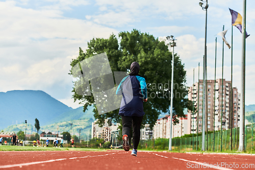 Image of A muslim woman in a burqa sports muslim clothes running on a marathon course and preparing for upcoming competitions