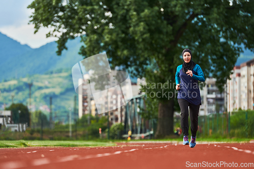 Image of A muslim woman in a burqa sports muslim clothes running on a marathon course and preparing for upcoming competitions