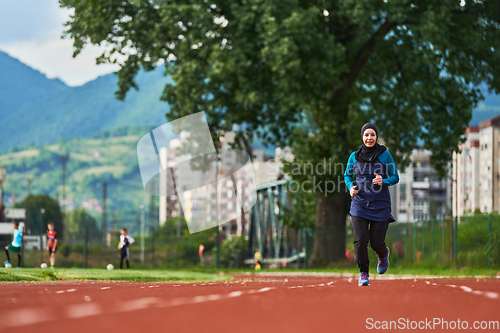 Image of A muslim woman in a burqa sports muslim clothes running on a marathon course and preparing for upcoming competitions