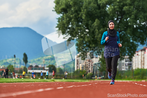 Image of A muslim woman in a burqa sports muslim clothes running on a marathon course and preparing for upcoming competitions