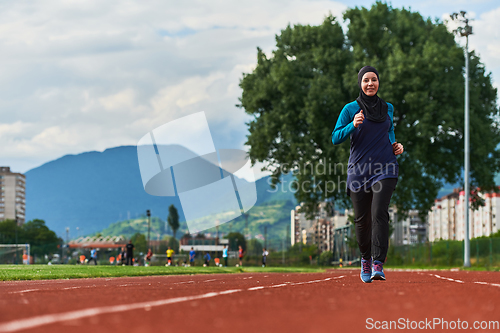 Image of A muslim woman in a burqa sports muslim clothes running on a marathon course and preparing for upcoming competitions