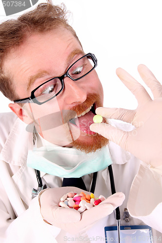 Image of doctor taking hand full of tablets 