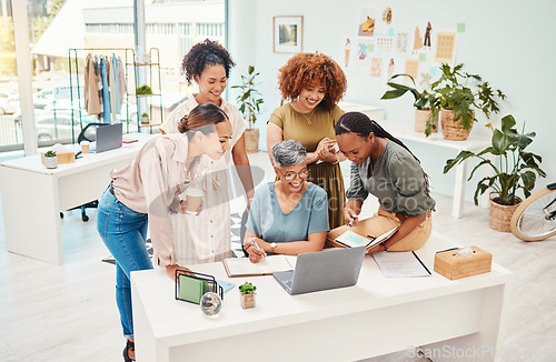 Image of Business women, fashion designer and laptop with teamwork, planning or brainstorming in office of website launch. Professional creative people in collaboration meeting, design review or happy project