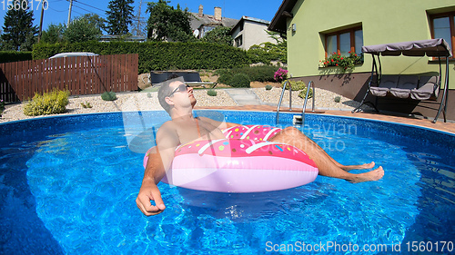 Image of Happy man relax on inflatable ring. Holiday 2020