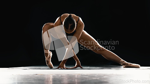 Image of Art, ballet and woman on black background stretching in dance performance with balance, stage and talent. Dark aesthetic, flexible ballerina or dancer with fitness, creativity and studio exercise.