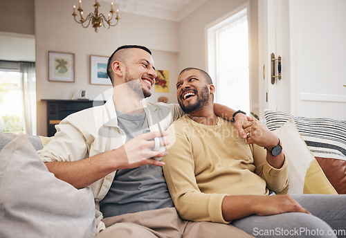 Image of Happy, home and a gay couple on the sofa with coffee, conversation or love in a house. Smile, together and lgbt men on the living room couch for a funny story, communication or speaking with tea
