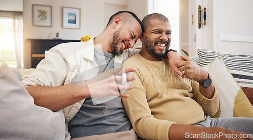Image of Laughing, relax and a gay couple on the sofa with coffee, conversation or love in a house. Happy, together and lgbt men on the living room couch for a funny story, communication or speaking with tea