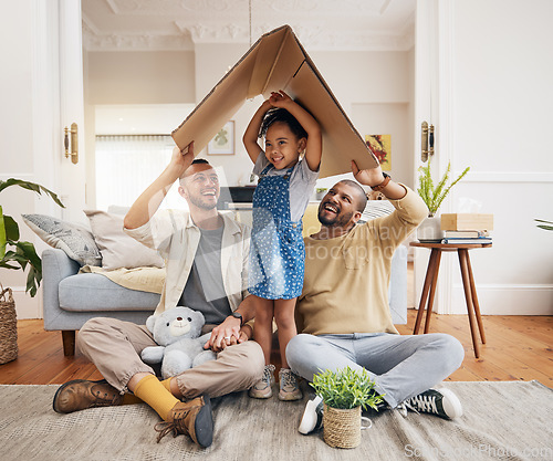 Image of Happy, gay family and a child with cardboard roof or home with love, care and safety in a lounge. Lgbtq men, adoption and parents with a foster girl kid together for new house, mortgage and insurance