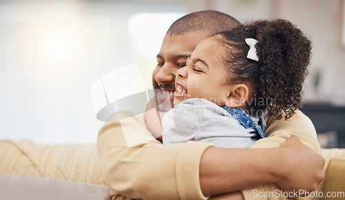 Image of Smile, love and girl hugging her father while relaxing on a sofa in the living room together. Happy, care and child bonding, embracing and sitting with her young dad in the lounge of their home.