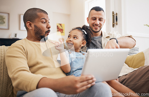 Image of Tablet, gay family and child on home sofa for e learning, watch video and education on internet. Adoption, lgbt men or parents with a happy kid and technology for streaming movies, games or app